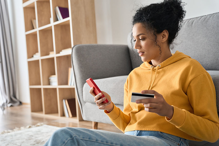 a woman uses her debit card to make a purchase online.